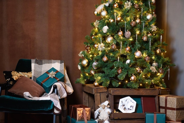 L'albero di Natale verde è decorato con lo spazio della copia della decorazione di Natale della poltrona di smeraldo dei giocattoli marroni