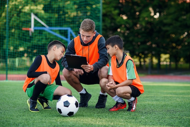 L'allenatore di calcio mostra una strategia di gioco del calcio ai suoi giocatori durante l'allenamento.