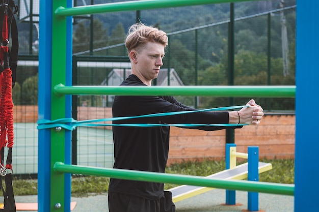 L'allenatore di fitness esercita la metà superiore del corpo su un campo da ginnastica all'aperto