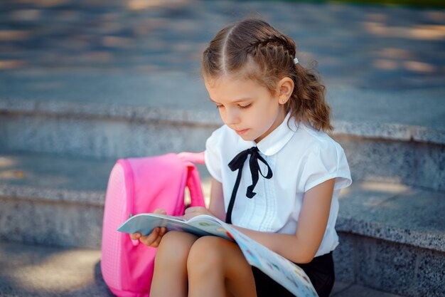 L'allievo della scuola primaria ha letto il libro che si siede sulle scale