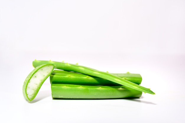 L'aloe vera a foglia verde fresca è una pianta medicinale comunemente usata per la salute e la bellezza. Impilate le piante fresche di aloe vera e gli steli o le foglie di aloe isolati su sfondo bianco