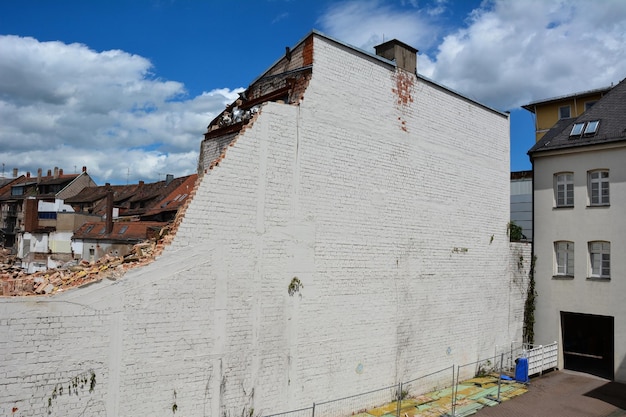 L'alto muro di mattoni semidistrutto della casa è destinato alla demolizione