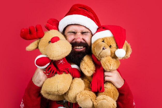 L'amore è nell'aria. buon Natale a te. tempo di shopping natalizio. preparare regali e regali. renne e orsi giocattolo. uomo barbuto felice in cappello di babbo natale. festa di fine anno. festeggiare le vacanze invernali.