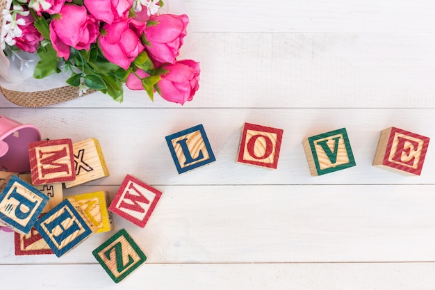 L&#39;AMORE scrive nel blocchetto di alfabeto di legno sul bordo di legno bianco