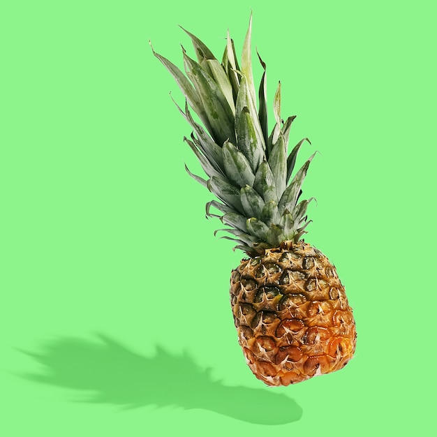 L'ananas vola nell'aria sul layout creativo luminoso, copia spazio