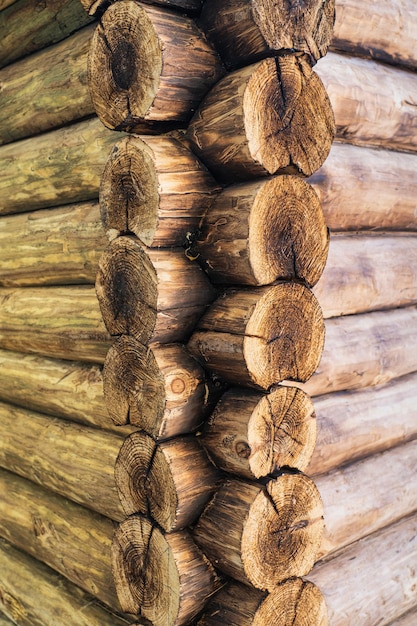 L'angolo di una casa fatta di tronchi di legno, l'angolo di una casa di tronchi tagliati. Foto verticale