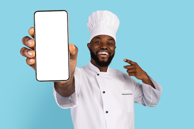 L'app di cucina ha eccitato lo chef nero che indica lo smartphone vuoto in mano