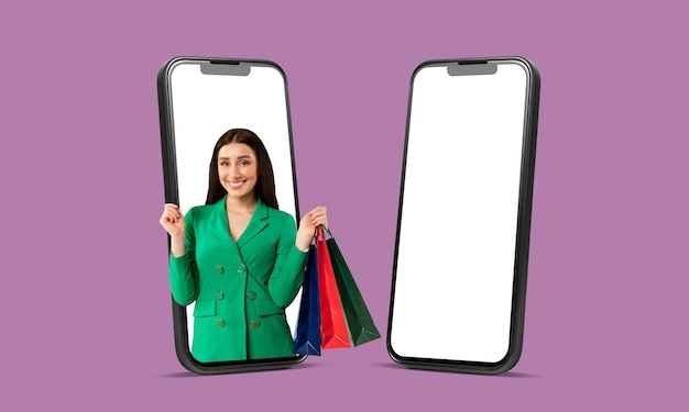 L'app per lo shopping mobile ha eccitato la signora shopaholic sullo schermo del telefono che tiene il cellulare con le borse dell'acquirente