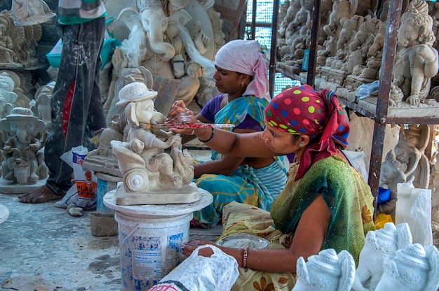 L'artista dà il tocco finale a un idolo del dio indù Lord Ganesha in un laboratorio di artisti per il festival di Ganesha