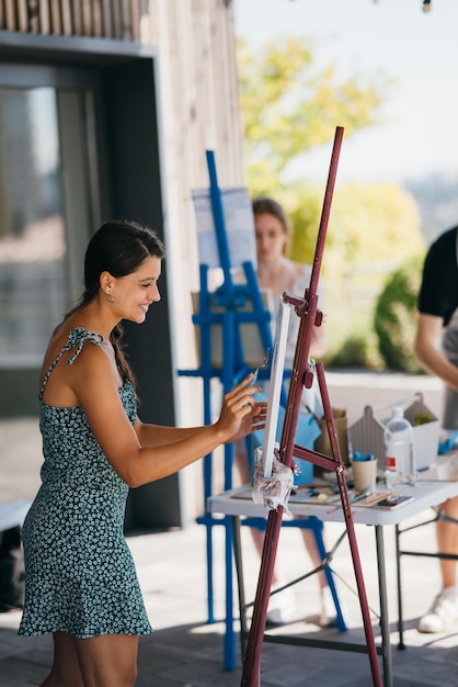 L'artista della giovane donna dipinge con una spatola sulla tela