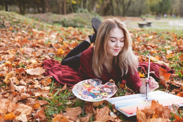 L'artista della giovane donna si sta rilassando nel parco per il suo hobby preferito.