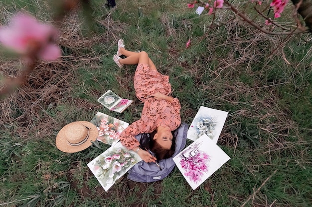 L'artista della ragazza dipinge un frutteto di pesche in una primavera di frutteto di pesche