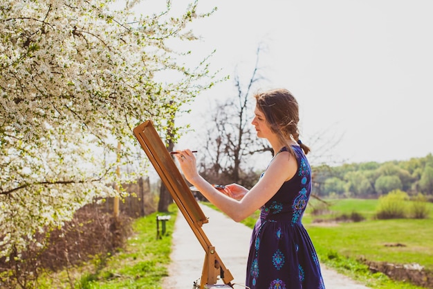 L'artista dipinge un'immagine di un ciliegio in fiore nel giardino
