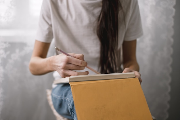 L'artista donna disegna un album da disegno a casa