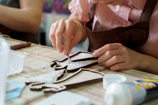 L'artista femminile delle mani raccoglie la fine del mosaico su