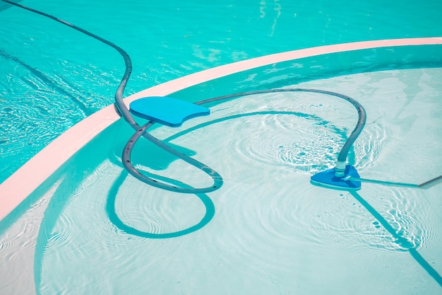 L'aspiratore d'acqua sul fondo della piscina. Pulizia della piscina. Aspirapolvere subacqueo.