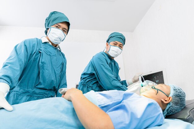 L'assistente chirurgo ha messo il paziente su una maschera di ossigeno ventilato in preparazione per l'intervento chirurgico