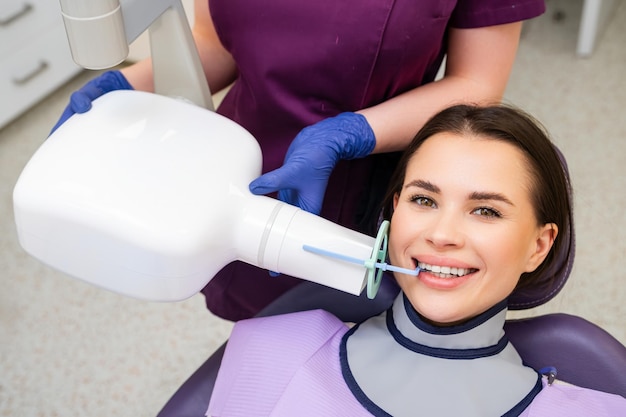 L'assistente dentale impiega strumenti specializzati per aiutare il paziente a prepararsi a una procedura di radiografia in
