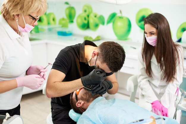 L'assistente dentista in presenza di un medico prepara il paziente a rimuovere il dente