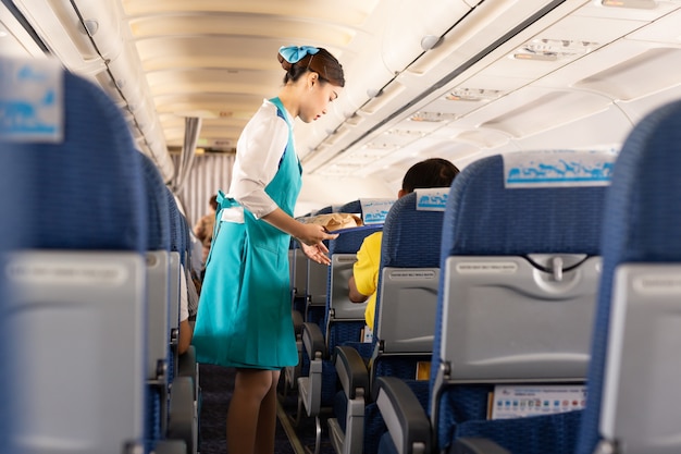 L'assistente di volo di Bangkok Airways serve da mangiare ai passeggeri a bordo.