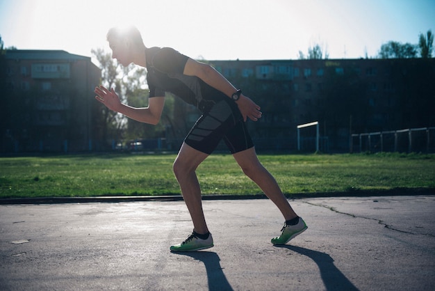 L'atleta allo stadio si trova sulla pista di partenza per correre