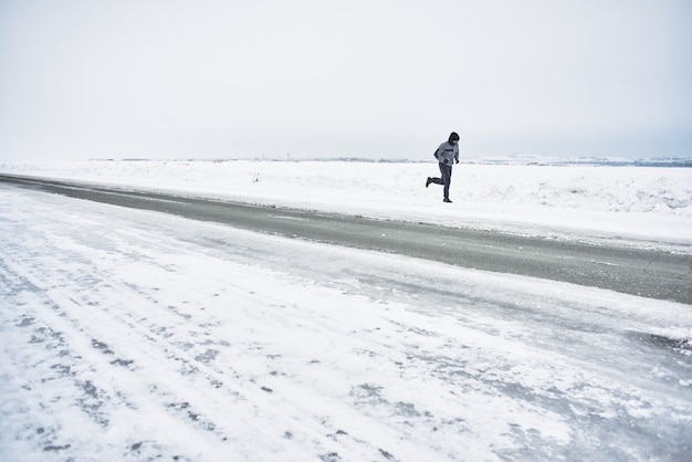 L'atleta corre in inverno su strada