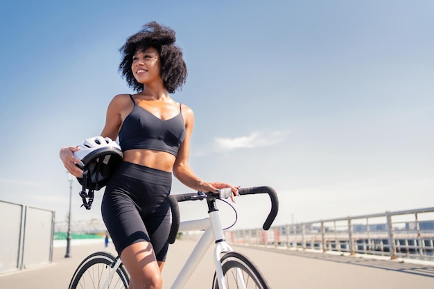 L'atleta è una donna felice in sella a una bicicletta in un trasporto ecologico di abbigliamento sportivo