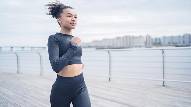 L'atleta femminile del corridore fa le corse di allenamento usa l'orologio di forma fisica