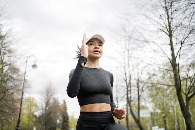 L'atleta femminile del corridore fa una corsa di allenamento attiva utilizza un orologio fitness