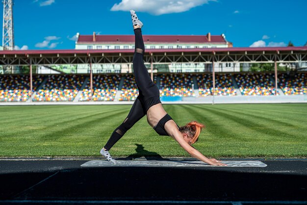 L'atleta femminile fa esercizio di allenamento sportivo o pilates in uno stile di vita attivo di sity staium