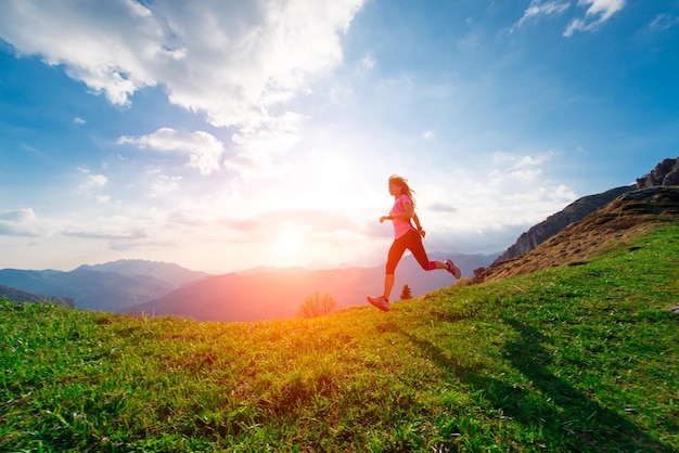 L'atleta femminile si allena nei prati collinari al tramonto