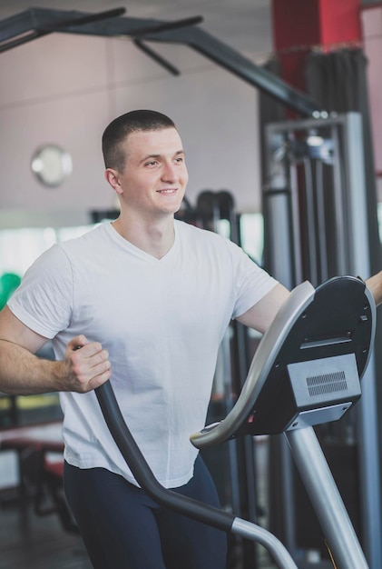 l'atleta si allena sul simulatore nel fitness club e sorride