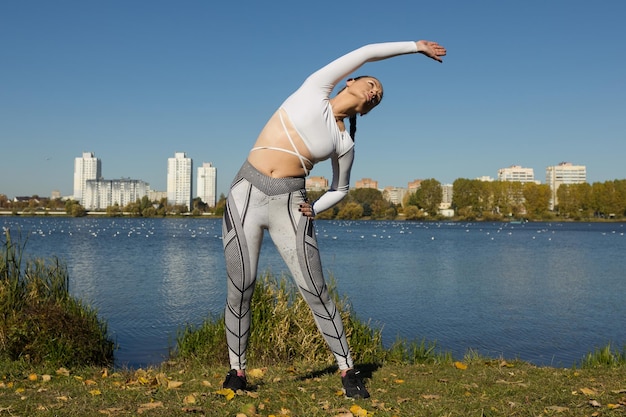 L'atleta si riscalda prima di un allenamento di corsa nel parco Bel tempo per fare jogging nel parco cittadino