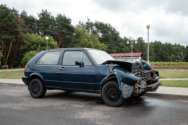 L'auto è parcheggiata dopo l'incidente, il cofano è rotto, le conseguenze della disattenzione sulle strade.