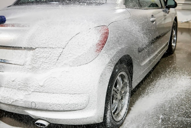 L'auto è ricoperta di schiuma per lavare l'auto Autolavaggio automatico Shampoo per auto Processo di pulizia selfservice