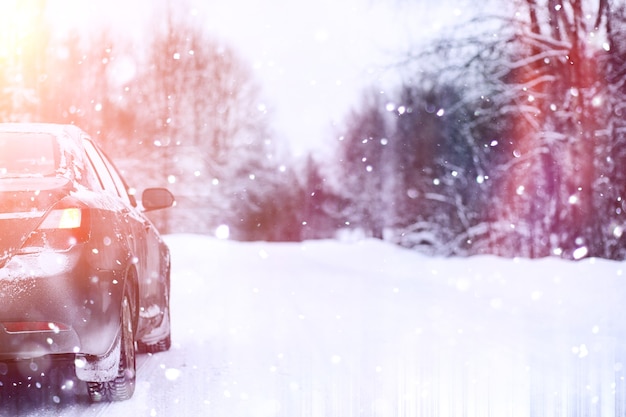 l'auto si trova su una strada coperta di neve in una giornata nuvolosa invernale