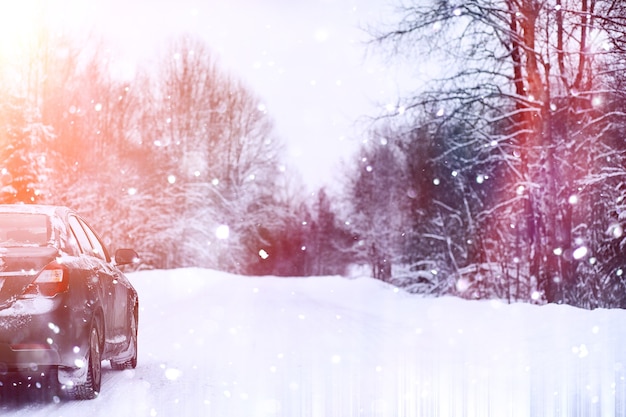 L'auto si trova su una strada coperta di neve in una giornata nuvolosa invernale