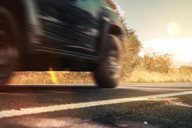 L'auto va veloce su strada sotto il sole