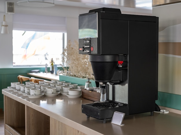 L Coffee station. Macchine da caffè e vassoi con tazze su un tavolo. grande macchina da caffè per self service a Buffet. Tazze per caffè e tè al banchetto. La stazione self-service. stazione del caffè