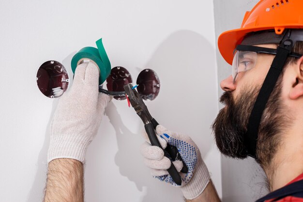 L'elettricista nel casco installa le prese