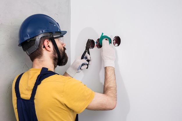 L'elettricista nel casco installa le prese