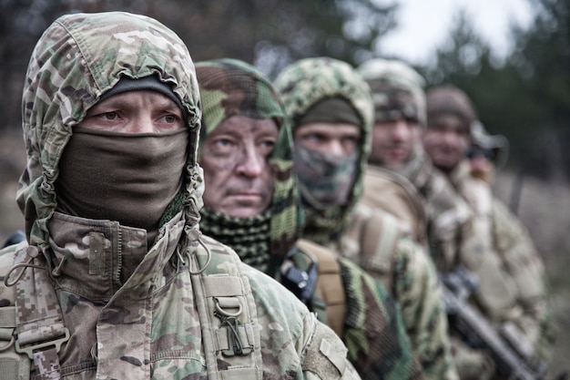 L'élite dell'esercito forza i soldati del gruppo tattico, la squadra di commando abile, i membri che indossano l'uniforme mimetica, i volti nascosti dietro le maschere, in fila dietro il comandante