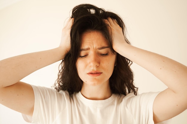 L'emicrania è un forte mal di testa della donna Una donna stressata si tocca la testa a causa del dolore Depressione della ragazza attraente