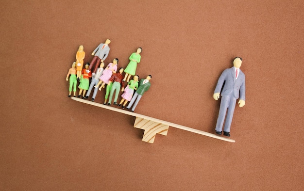 L'equilibrio tra persone in miniatura lavoratori e leader il leader è più pesante i leader sono più preziosi