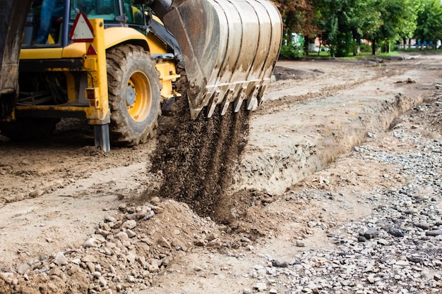 L'escavatore si addormenta una trincea. Costruzione in una zona suburbana