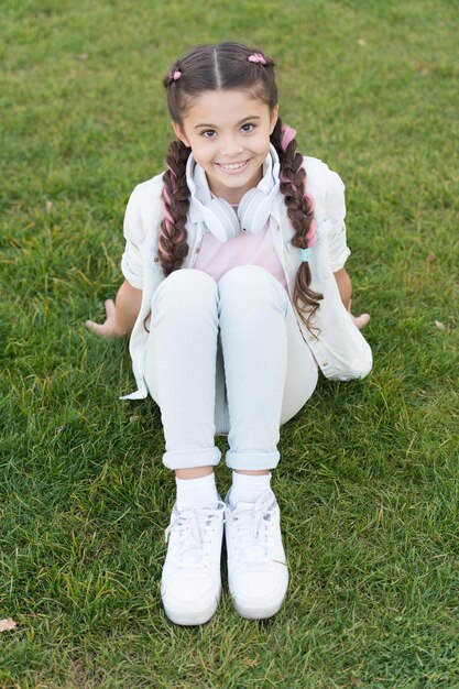 L'estate significa tempi felici e buon sole. Bambino piccolo che si gode le vacanze estive. Bambina rilassante sull'erba verde il giorno d'estate. Estate. Estate.