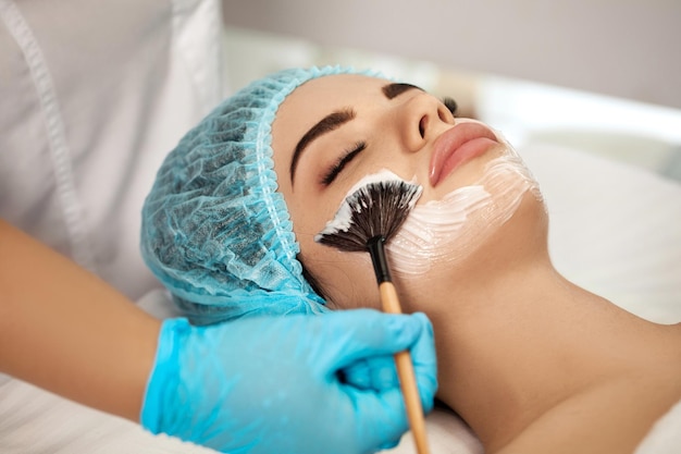 L'estetista applica la maschera facciale sulla donna