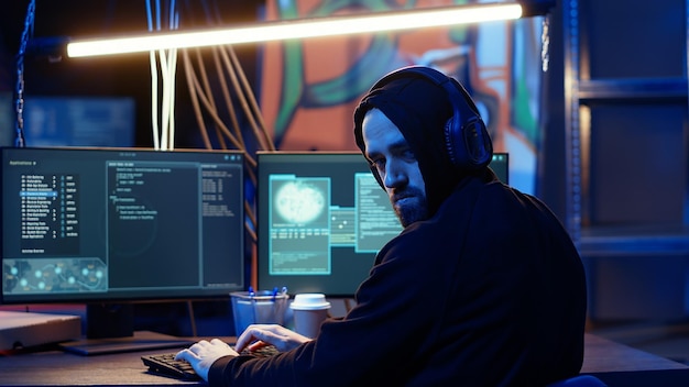 L'hacker guarda ansiosamente oltre la spalla temendo di essere catturato e andare in prigione.