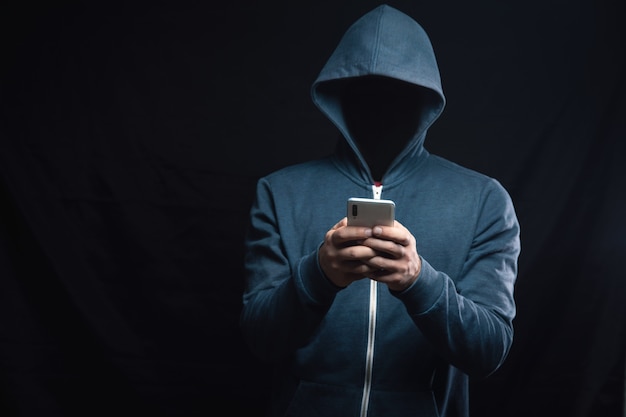 l'hacker nel cofano tiene il telefono