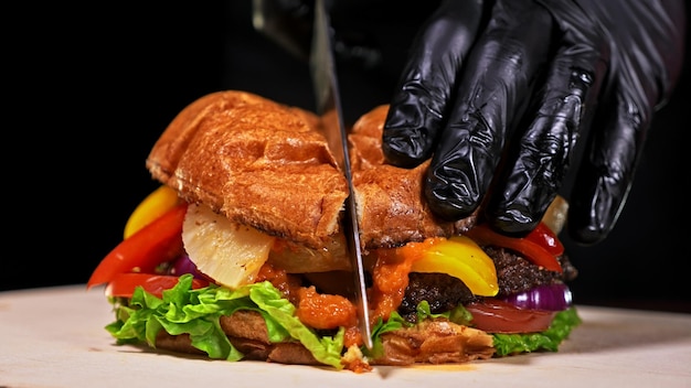 L'hamburger artigianale sta cucinando su sfondo nero